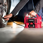 Man using cordless worcraft inflator to inflate car tire