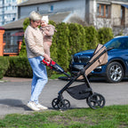 A woman uses a Worcraft handheld vacuum cleaner attached to clean a baby stroller
