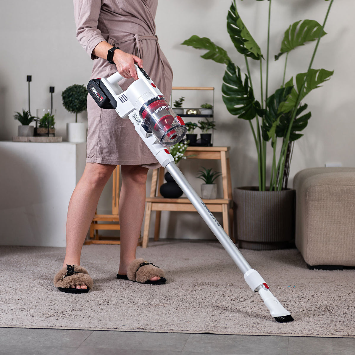 A person uses a Worcraft cordless stick vacuum cleaner on at home