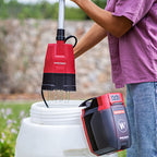 Person using Worcraft cordless rain barrel pump to water garden