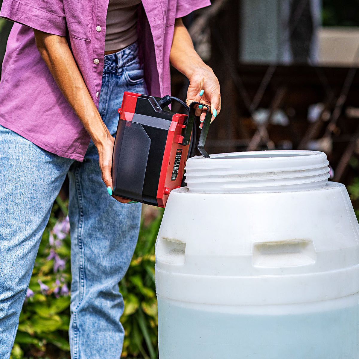 Person using their Worcraft cordless rain barrel pump