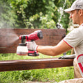 Man spraying paint on a bench using a Worcraft paint sprayer