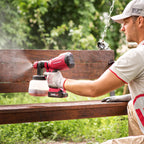 Man spraying paint on a bench using a Worcraft paint sprayer