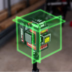 Worcraft tool laser level device with green laser lines projected in a cube shape, shown in a workshop setting.