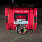 A red Worcraft Workstation carrying case with a black and red Worcraft XCUBE026 K20 Pro laser level placed in front of it on a concrete floor. Green and red laser lines are visible on the floor, and the background is a dark workshop environment.