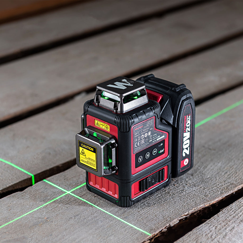 A red and black 20V 1M laser level sits on a weathered wooden deck, emitting a green laser grid across the surface.
